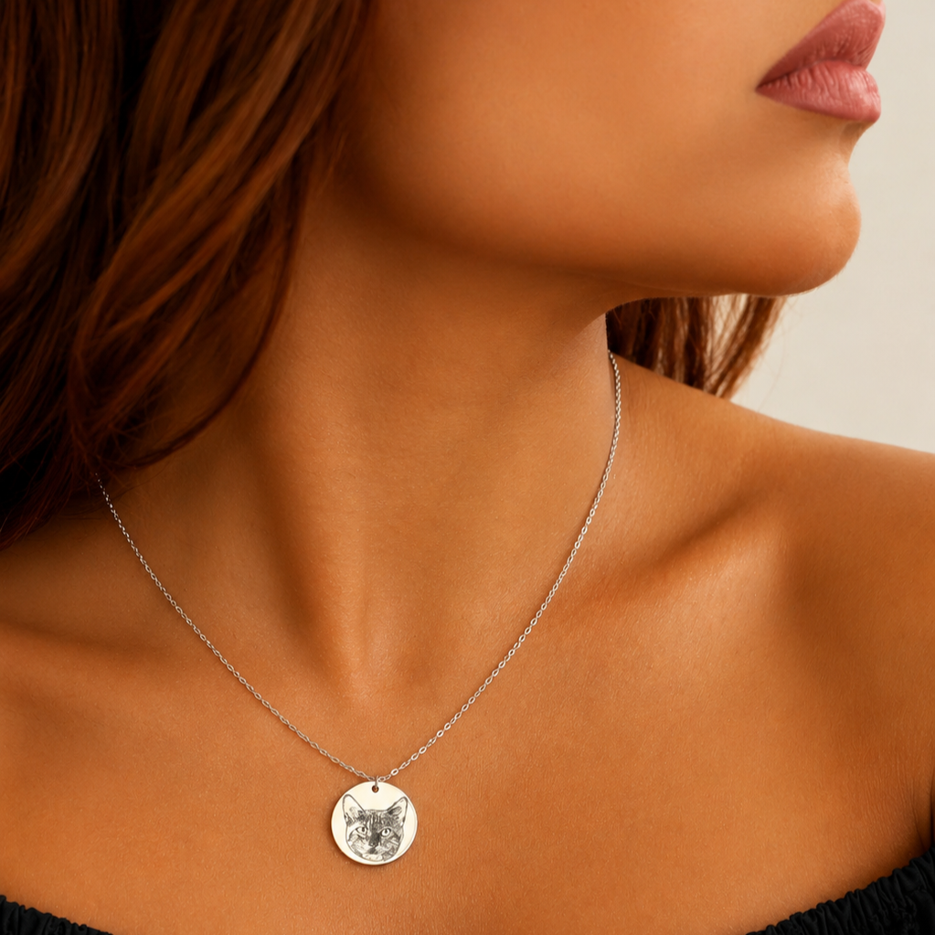 Silver-tone round pendant necklace featuring a cat portrait worn at the neckline