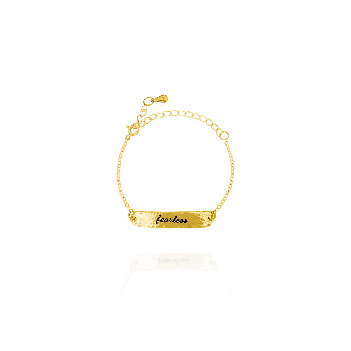 Gold-tone hammered bar bracelet engraved fearless on a white background