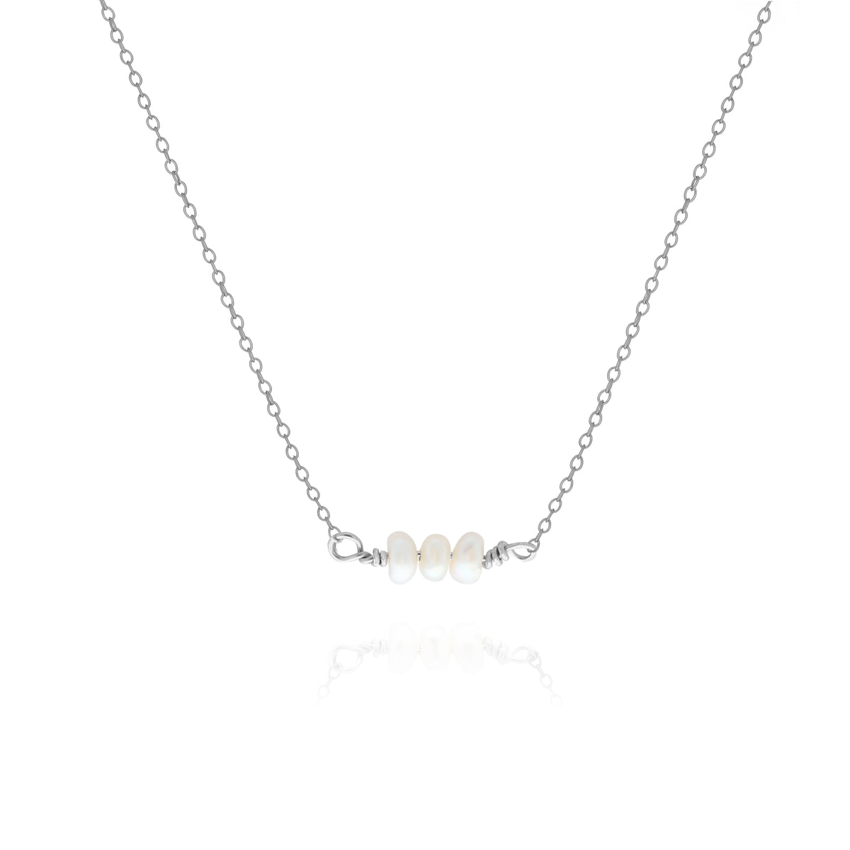 Silver-tone necklace with a short row of white oval pearls on a white background