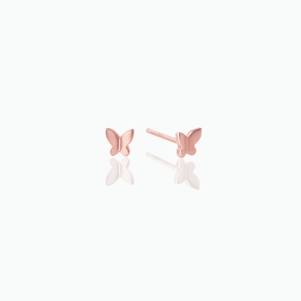Rose gold butterfly earrings on a white background