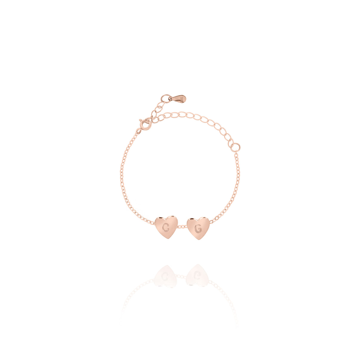 Rose-gold-tone bracelet with two engraved heart charms and adjustable chain on white background