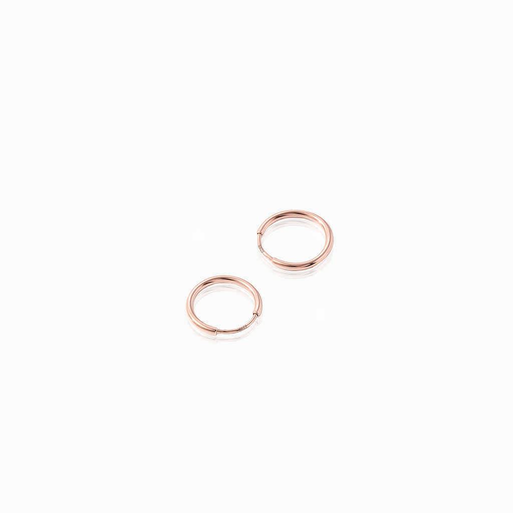Pair of rose gold hoop earrings on a white background