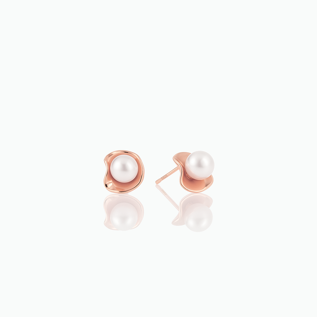 Pair of pearl earrings with rose gold posts on a white background