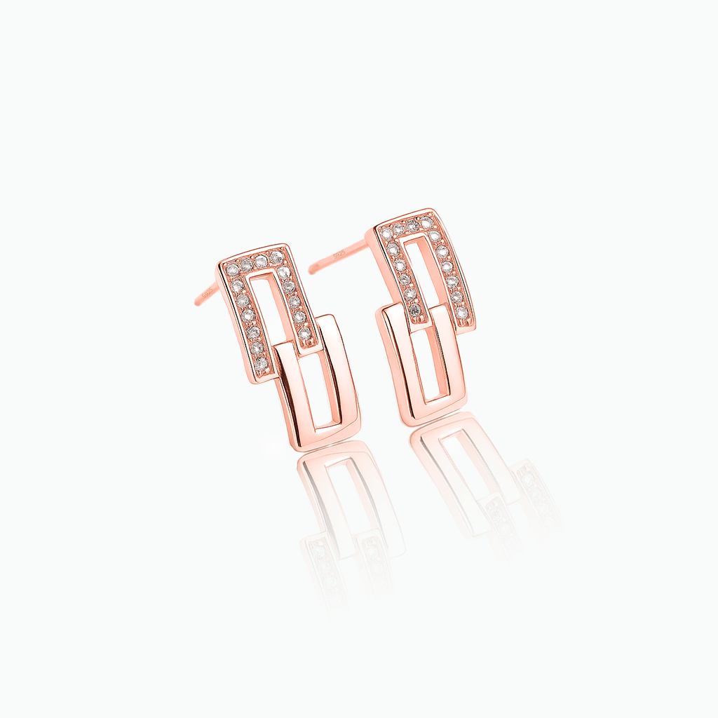 Rose gold earrings with clear gemstones on a white background