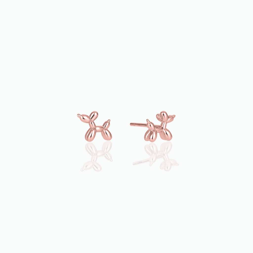 Rose gold balloon dog-shaped earrings on a white background