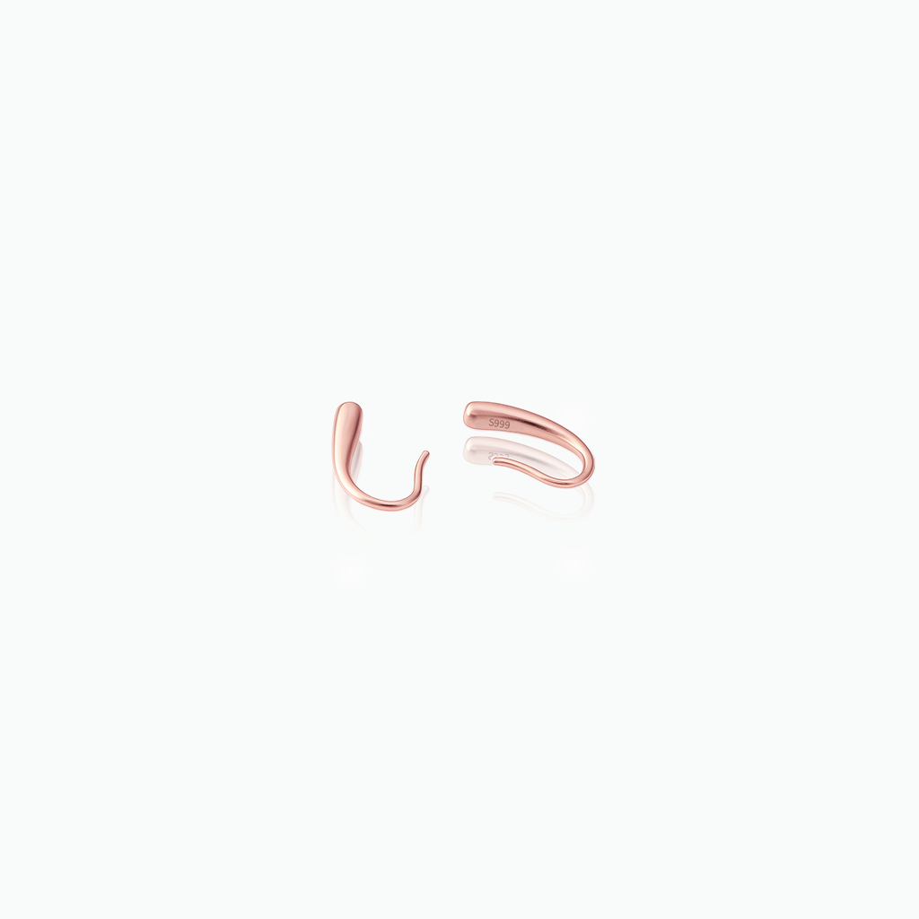 Rose gold open cuff earrings on a white background