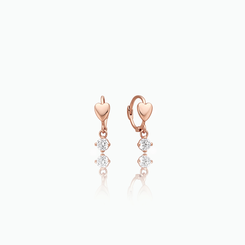 Rose gold heart-shaped earrings with diamond-like stones on a white background