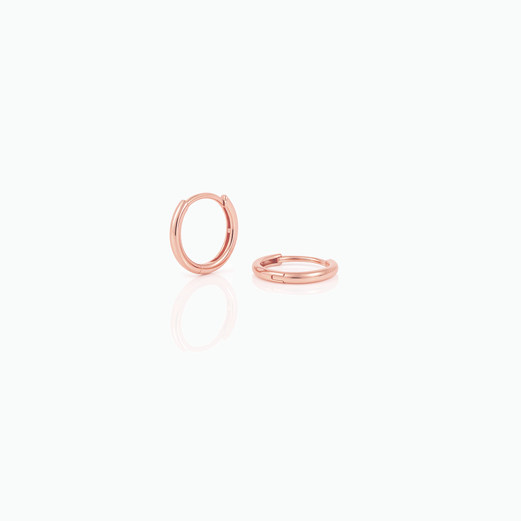 Two rose gold hoop earrings on a white background