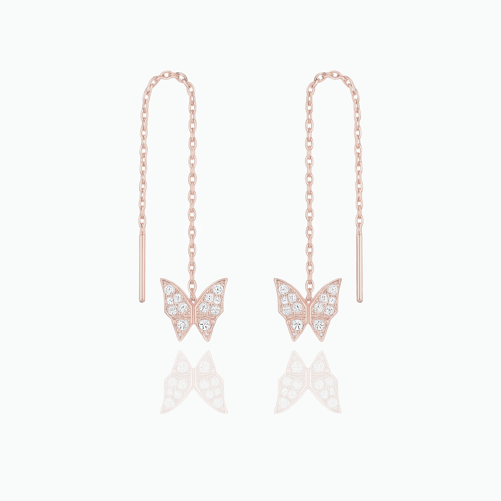 Rose gold butterfly earrings with chain drops on a white background