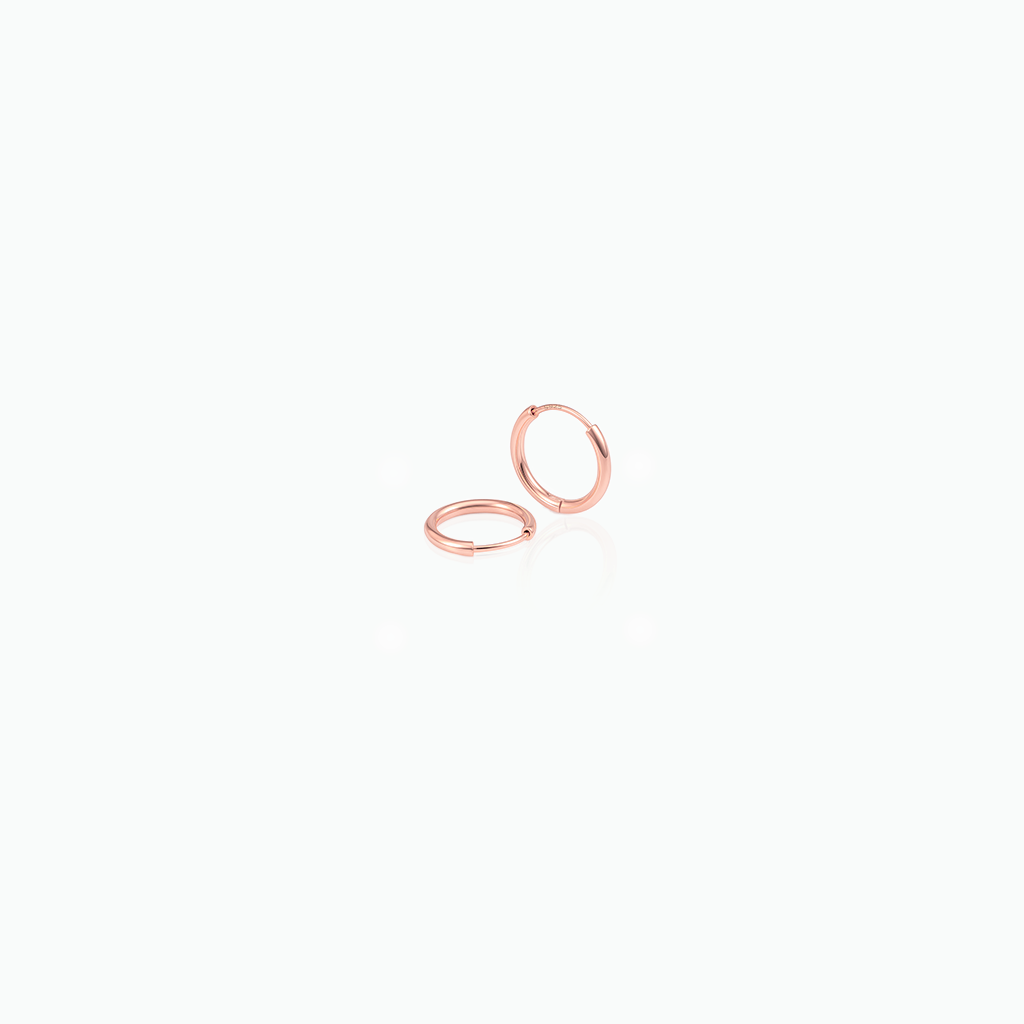 Pair of rose gold hoop earrings on a white background