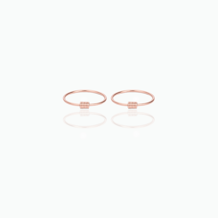 Pair of rose gold hoop earrings on a white background