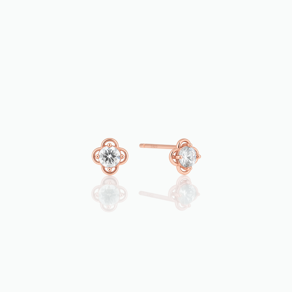 Rose gold earrings with clear gemstones on a white background