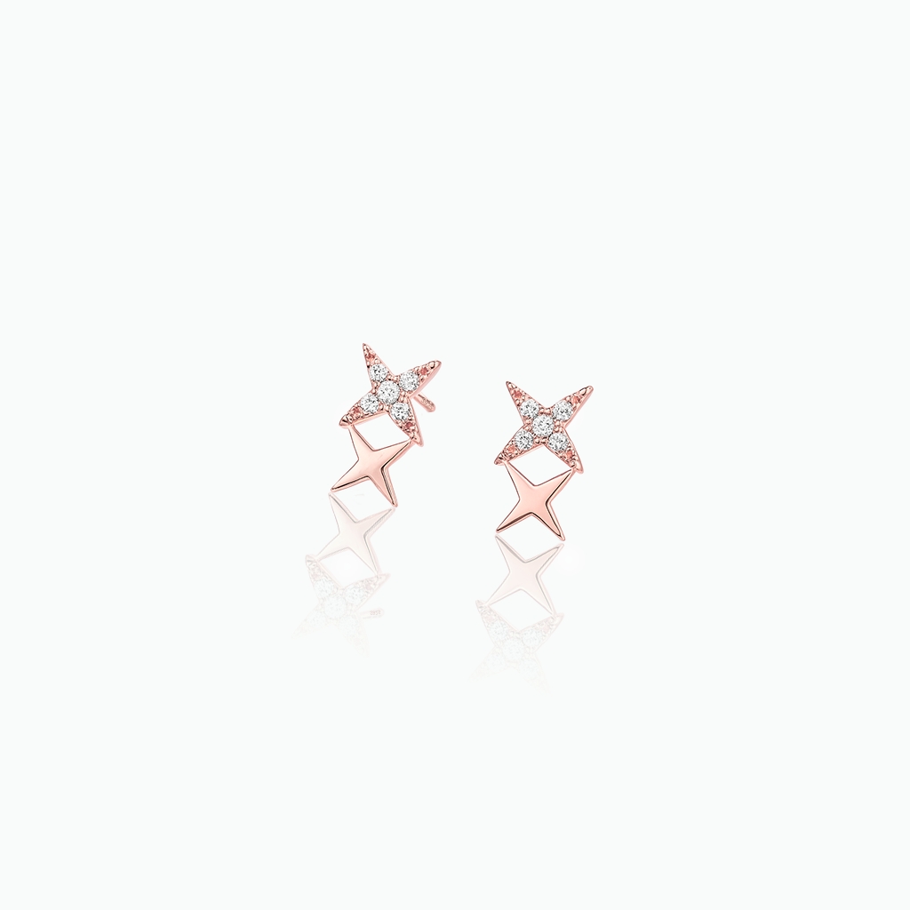 Rose gold star-shaped earrings with clear gemstones on a white background