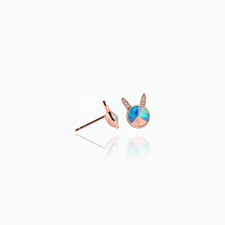 Rose gold earrings with colorful gemstones on a white background