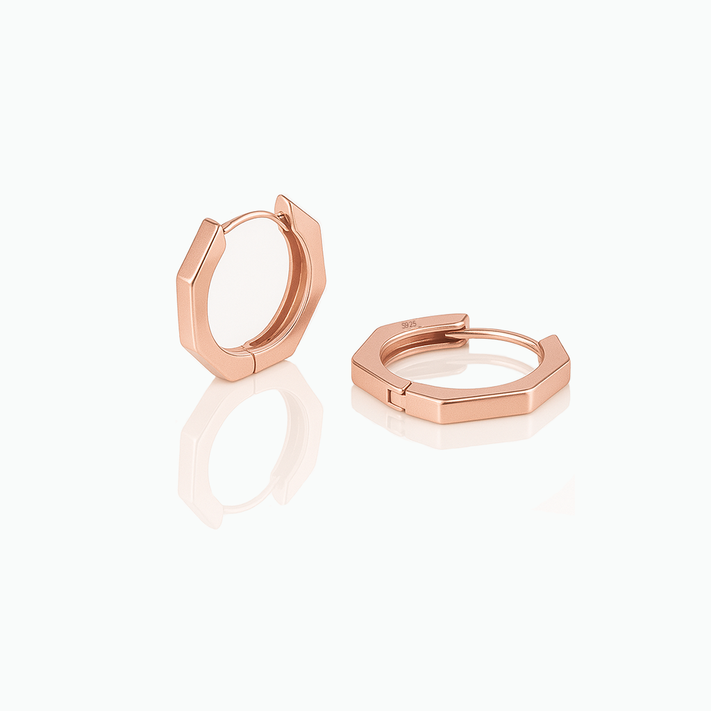 A pair of minimalist hexagon huggie earrings in rose gold color, crafted from 925 sterling silver, displayed on a white background.