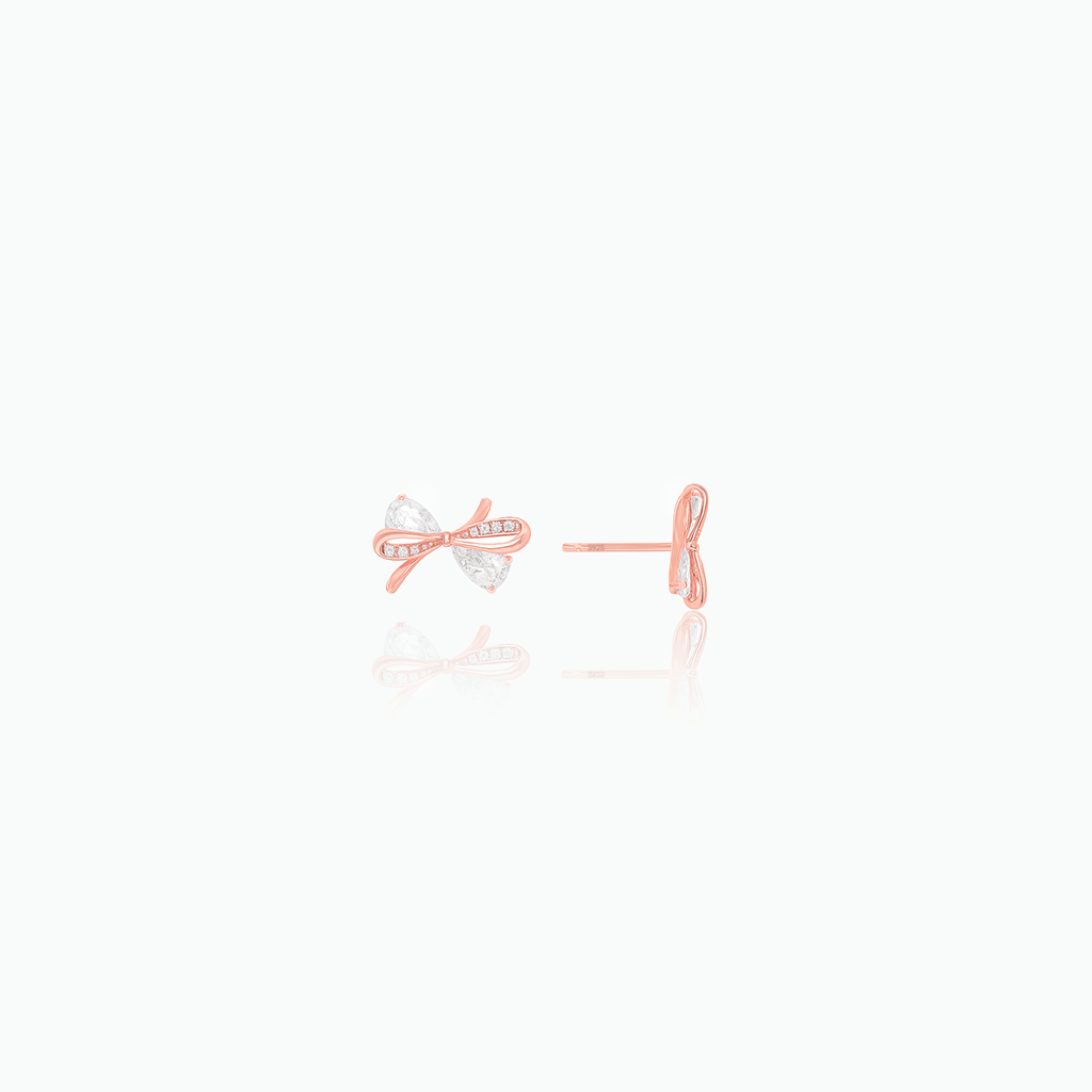 Rose gold bow-shaped earrings on a white background