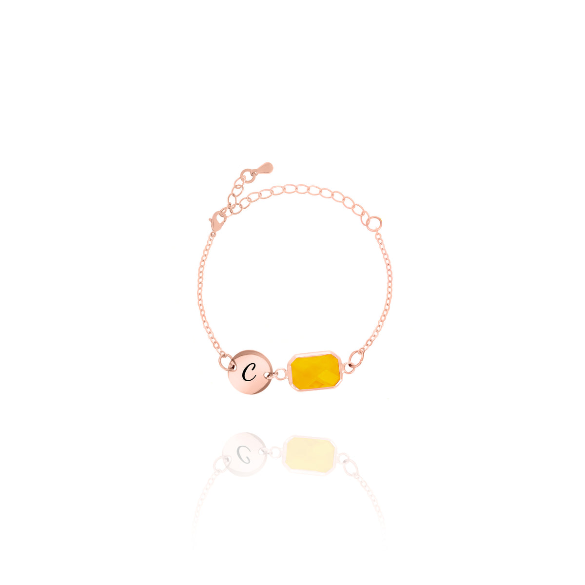 Rose-gold-tone bracelet with engraved C initial disc and orange rectangular stone on white background