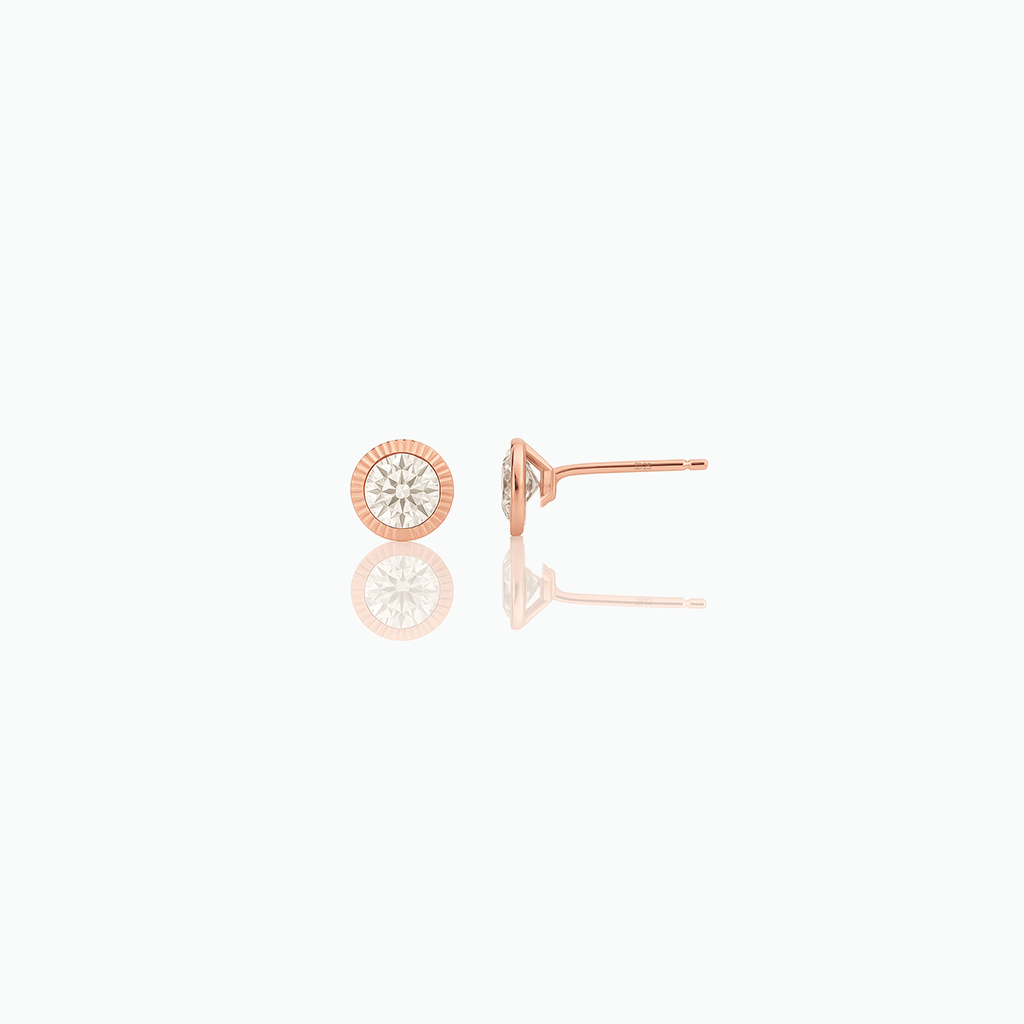 Rose-gold-tone round stud earrings with clear center stones on a white background