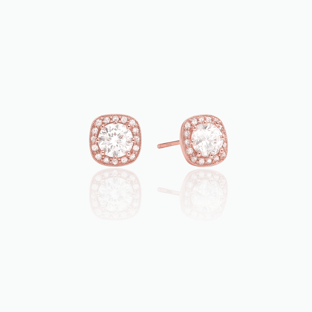 Rose gold earrings with clear gemstones on a white background