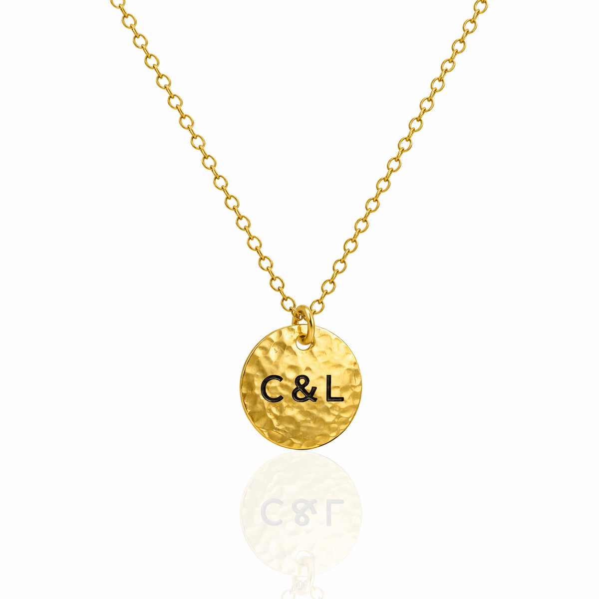 Gold-tone hammered disc necklace engraved with C&L on a white background