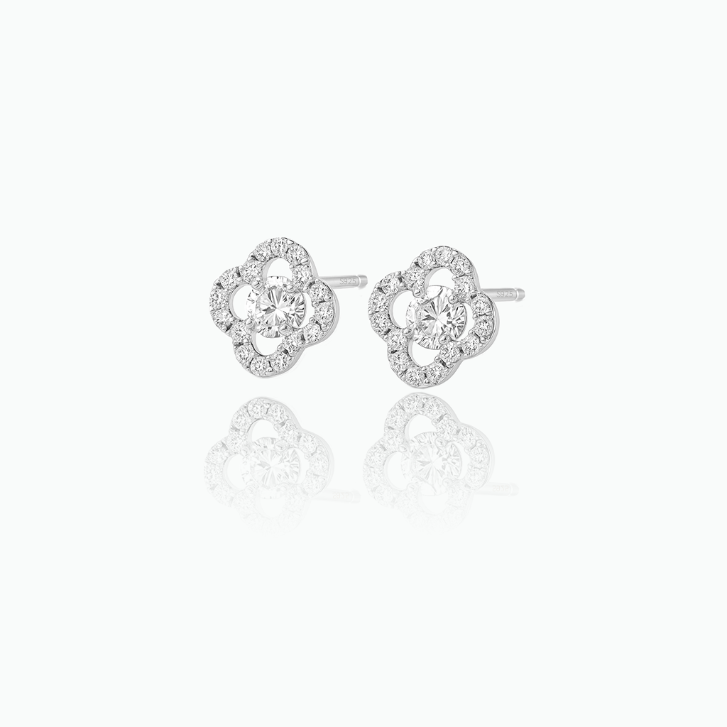 Pair of silver earrings with clear gemstones on a white background