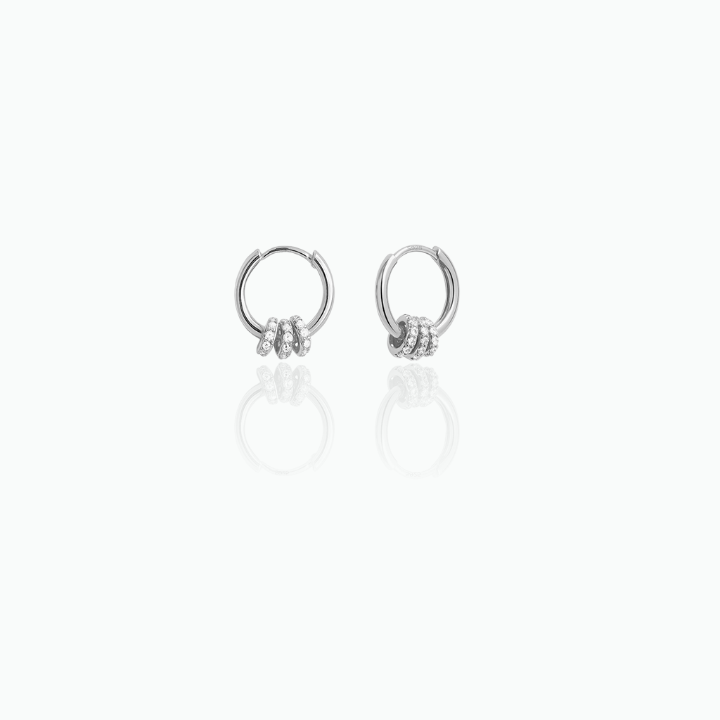 Pair of silver hoop earrings with small stones on a white background