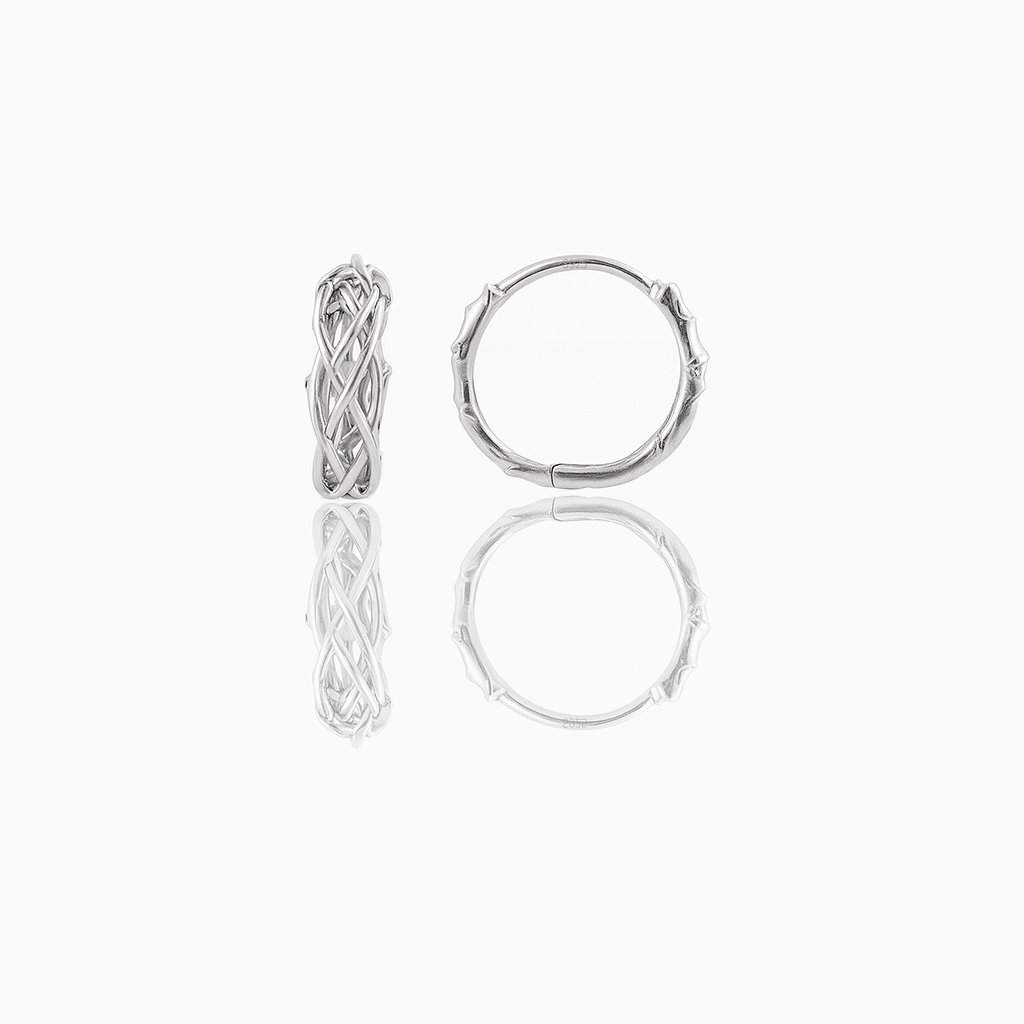 Pair of silver-tone minimalist huggie hoop earrings displayed on a white background