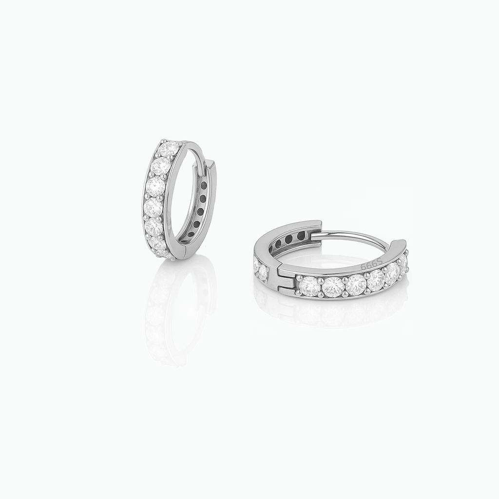 Pair of silver hoop earrings with clear gemstones on a white background