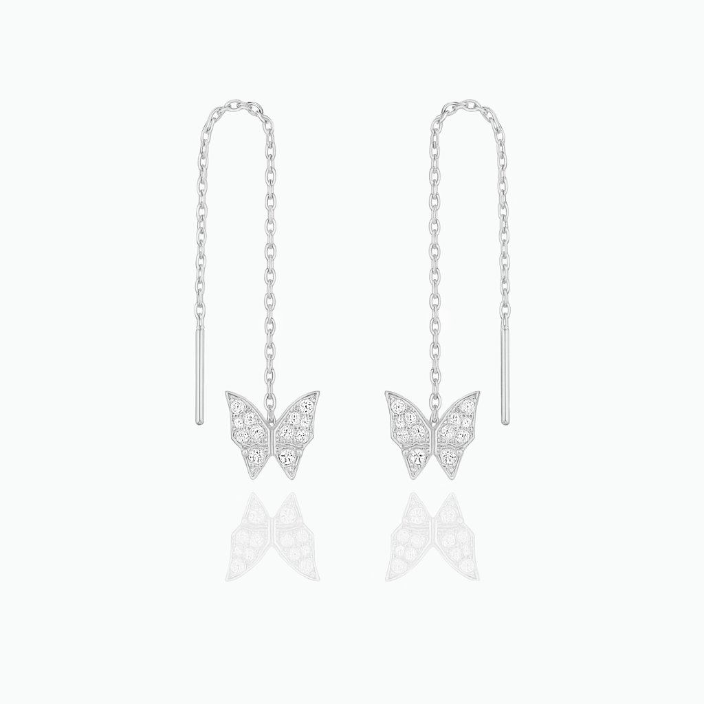 Butterfly earrings on thin chains against a white background
