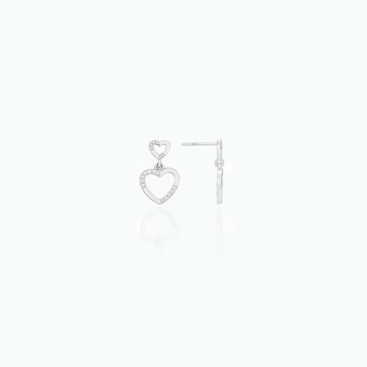 Heart-shaped silver earrings on a white background