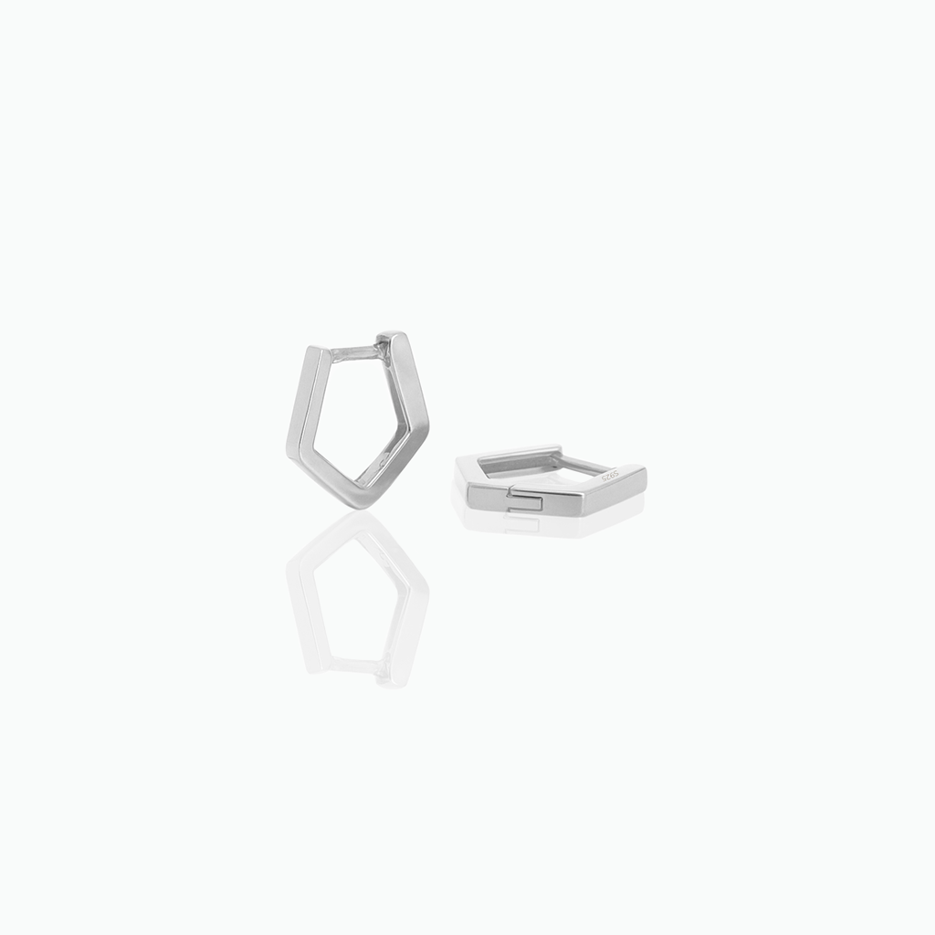 Silver geometric huggie hoop earrings on a white background