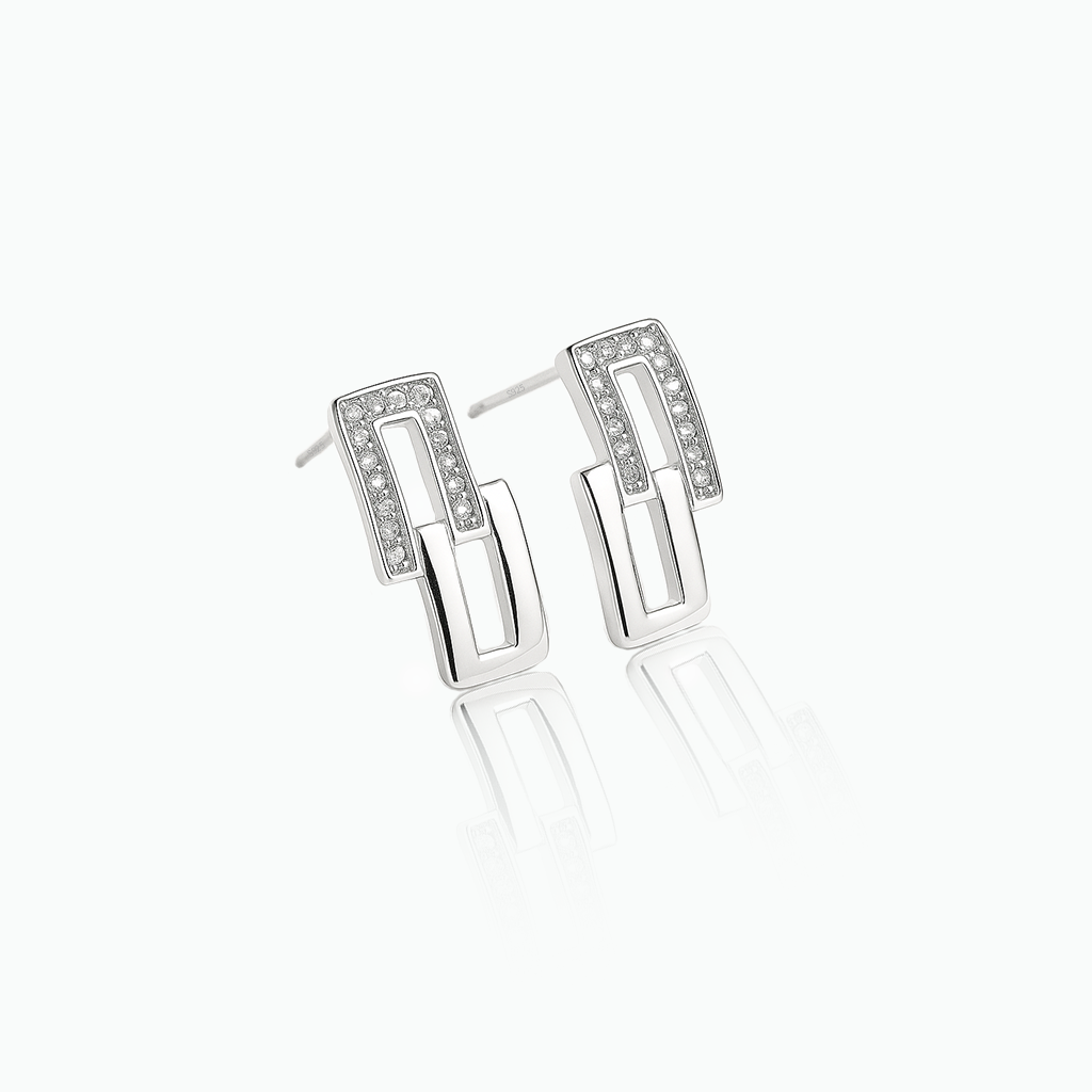 Pair of silver earrings with clear stones on a white background