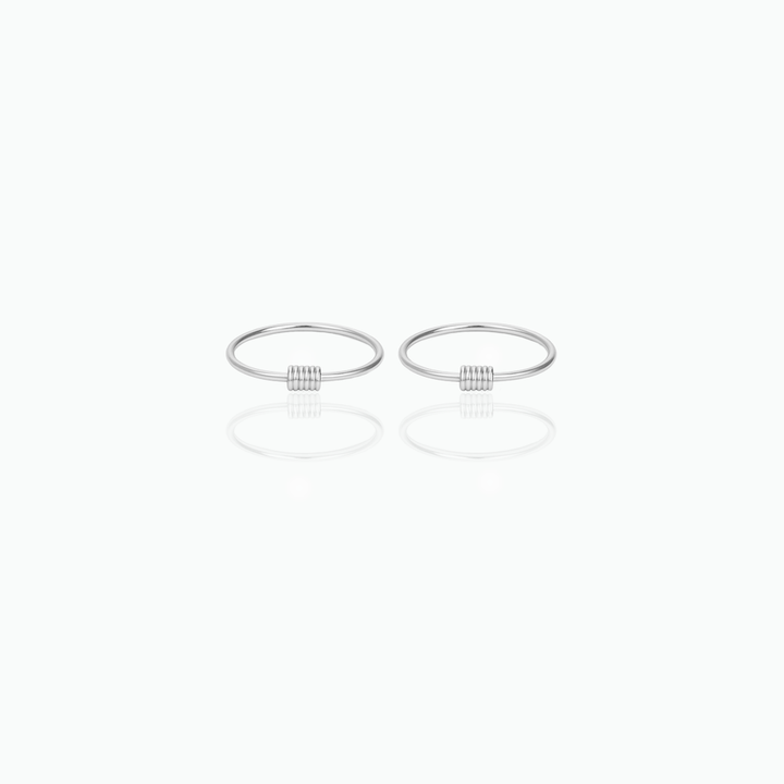 Two silver rings hoop earrings on a white background