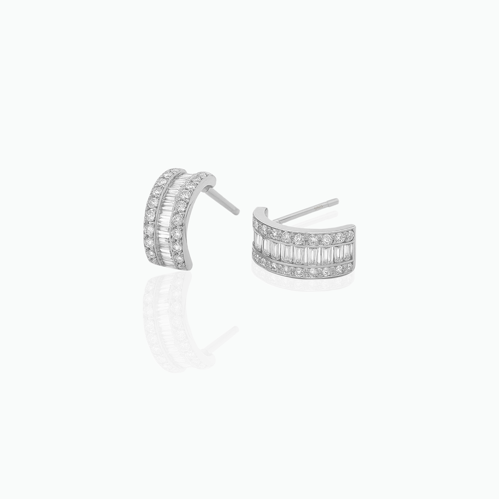 Pair of silver hoop earrings with clear gemstones on a white background