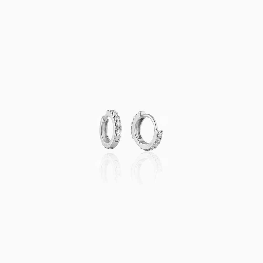 Silver hoop earrings with small diamonds on a white background