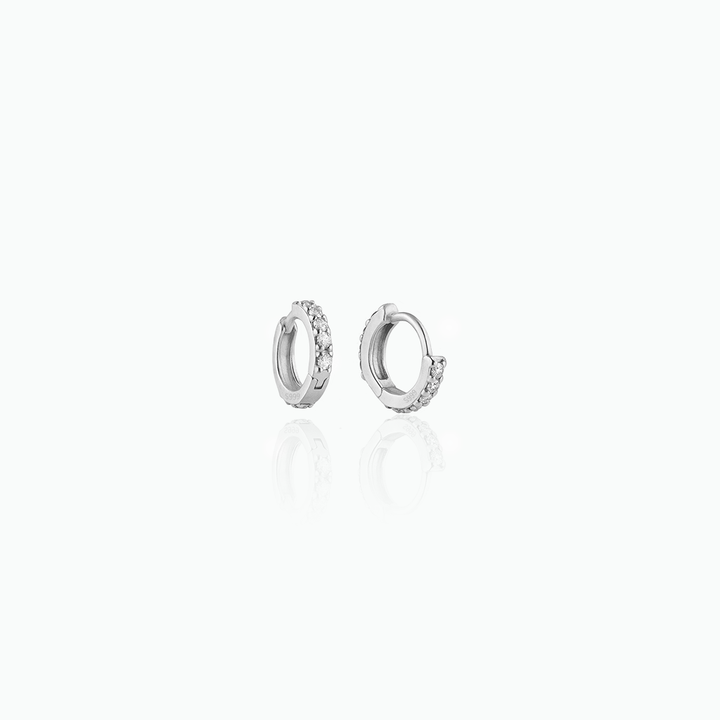 Silver hoop earrings with small diamonds on a white background
