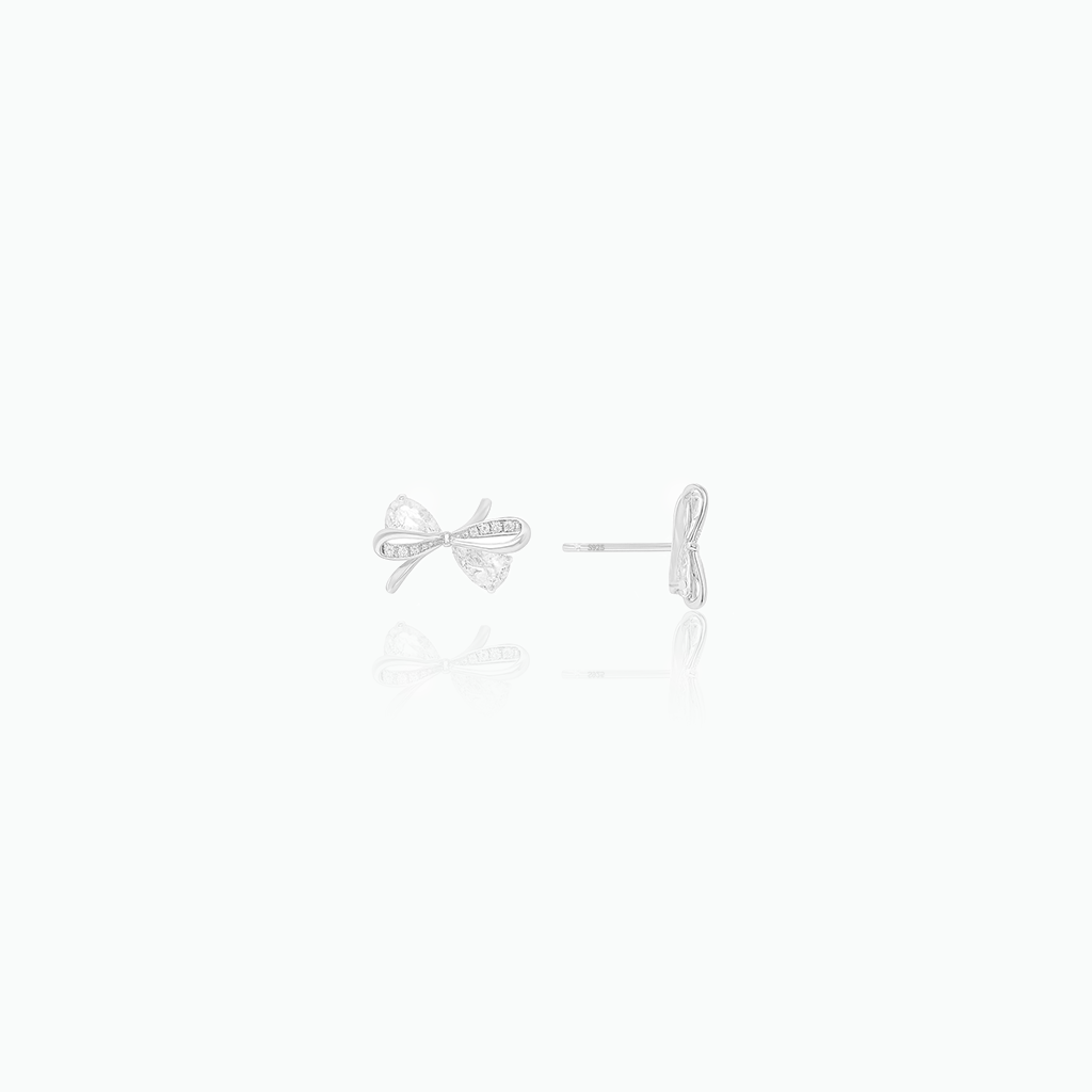 Pair of silver bow-shaped earrings on a white background