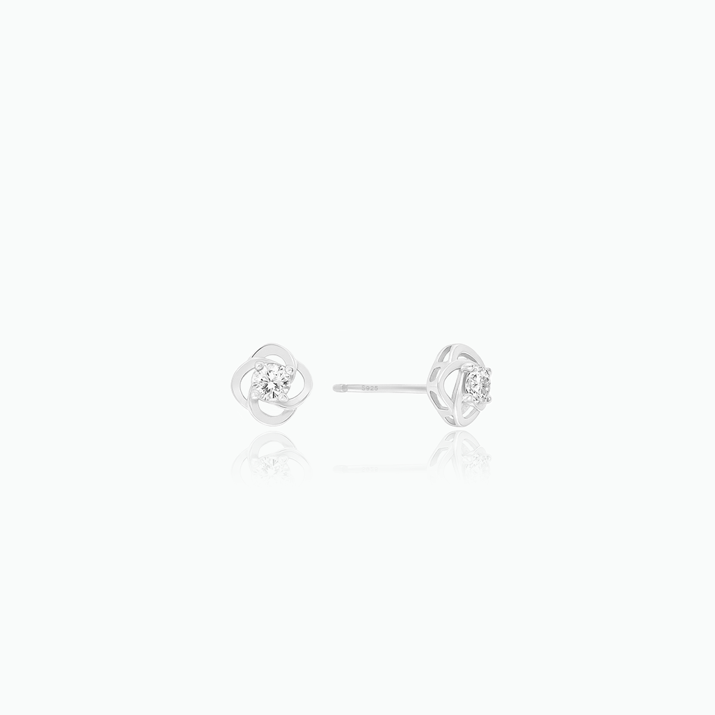 Pair of silver earrings with a small round gemstone on a white background