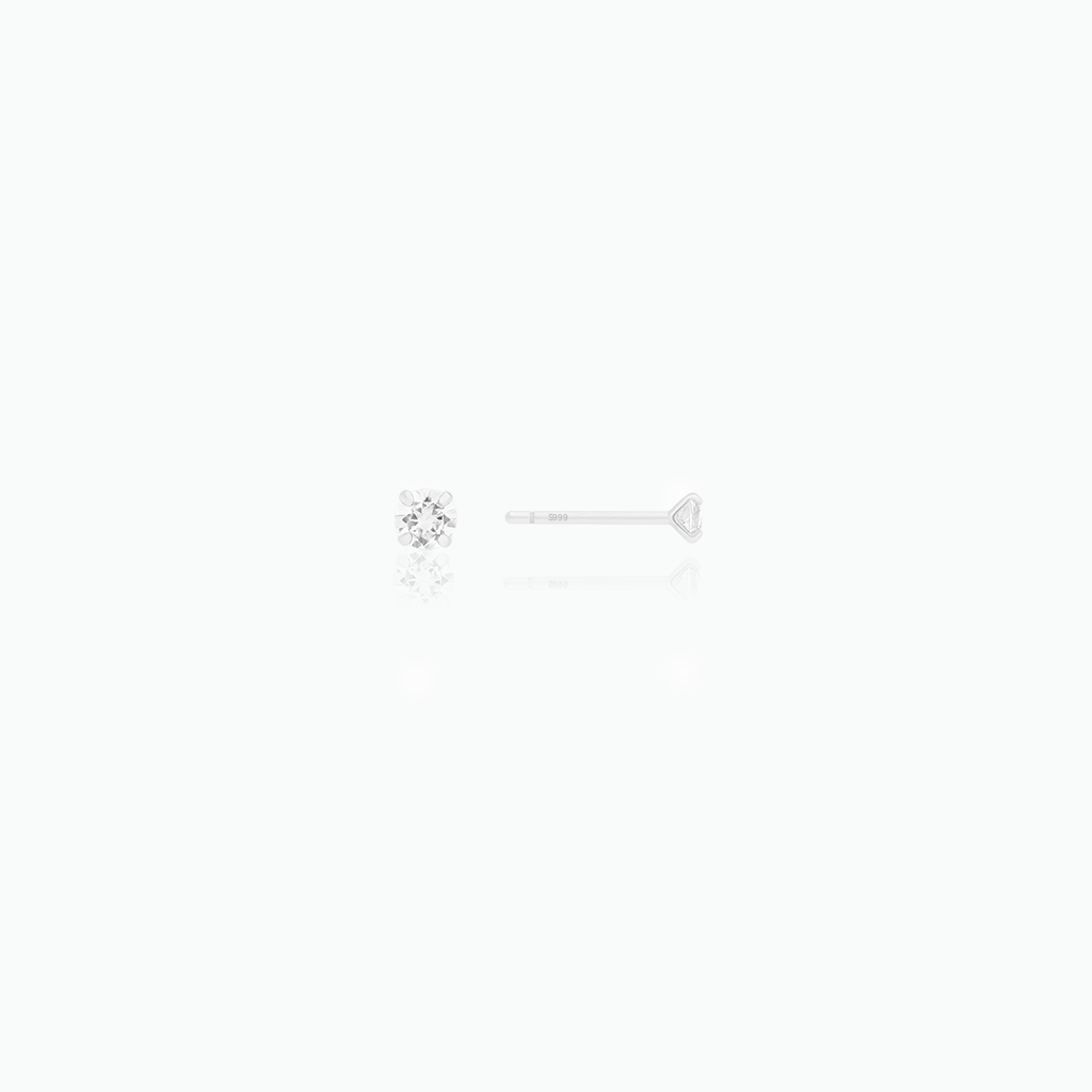 Silver earring with a clear gemstone on a white background