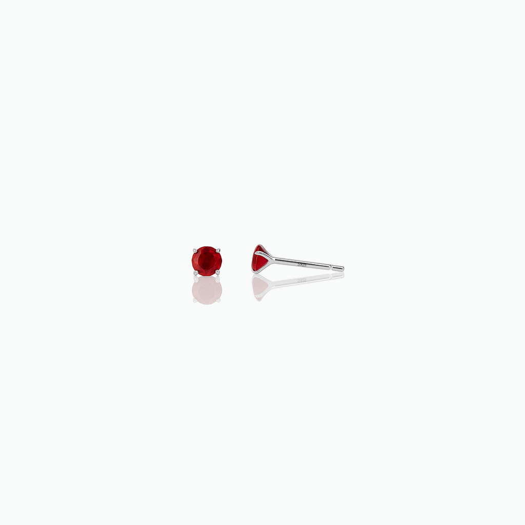 Single red gemstone stud earring on a white background