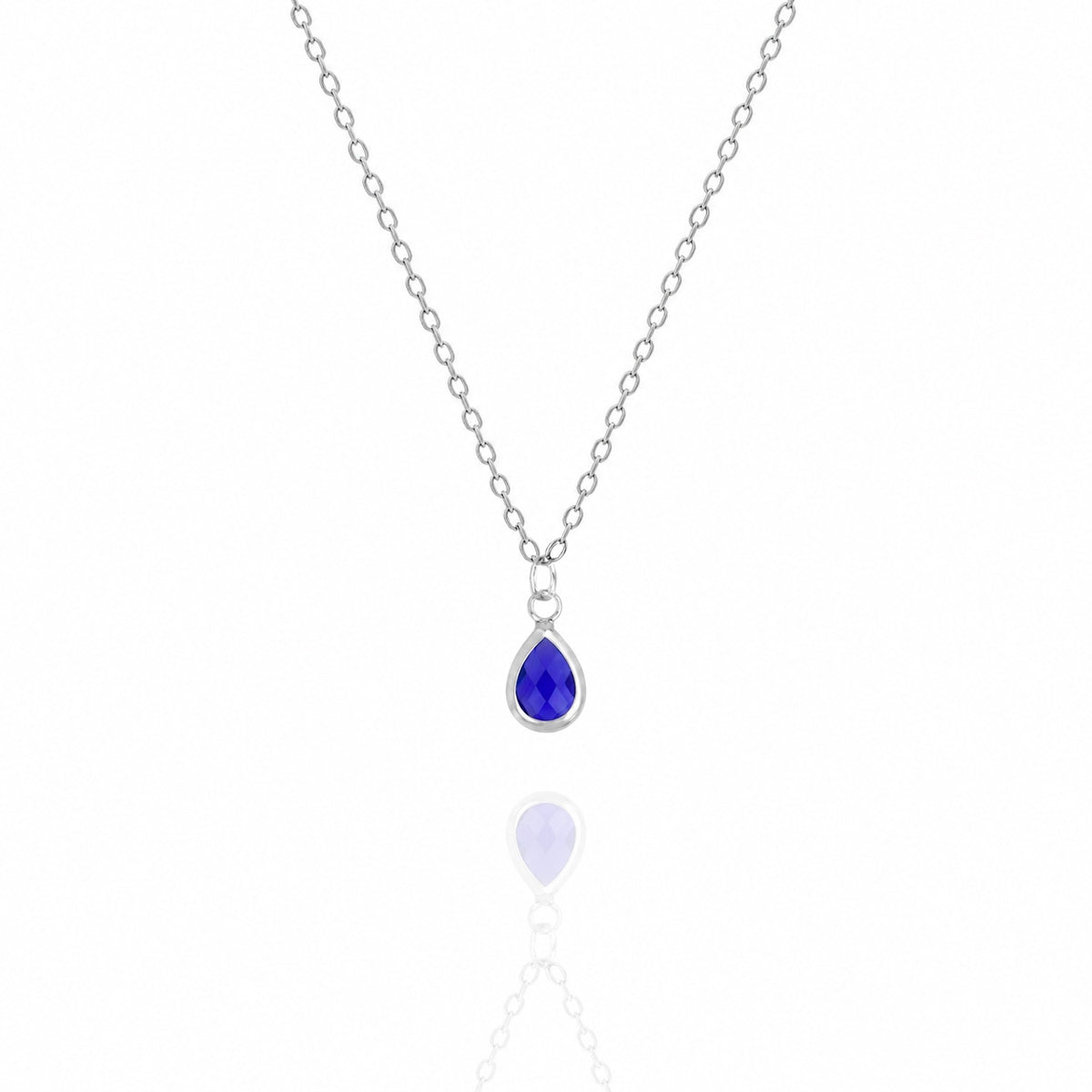 Silver-tone necklace with a deep blue teardrop pendant on a white background