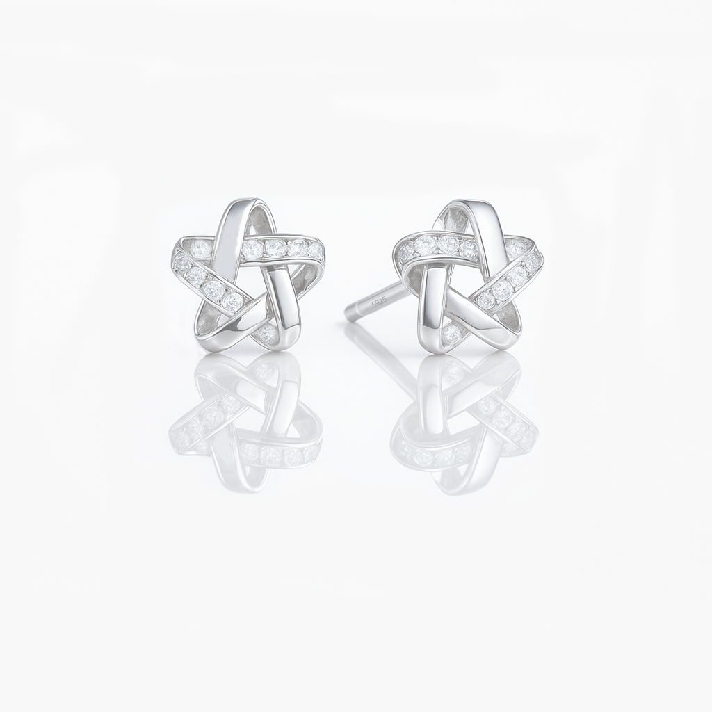A pair of dainty sterling silver star earrings with a silver finish and small sparkling stones embedded in the design.
