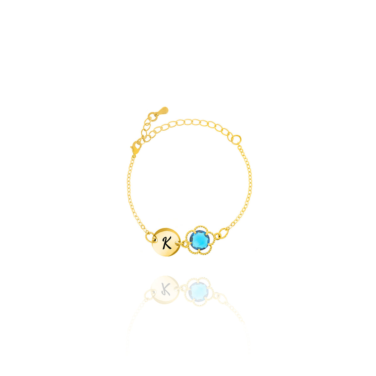 Gold-tone bracelet with engraved K initial disc and blue round stone in a beaded frame on white background