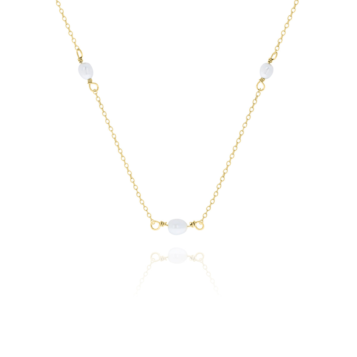 Gold-tone necklace with three white oval beads displayed on a white background