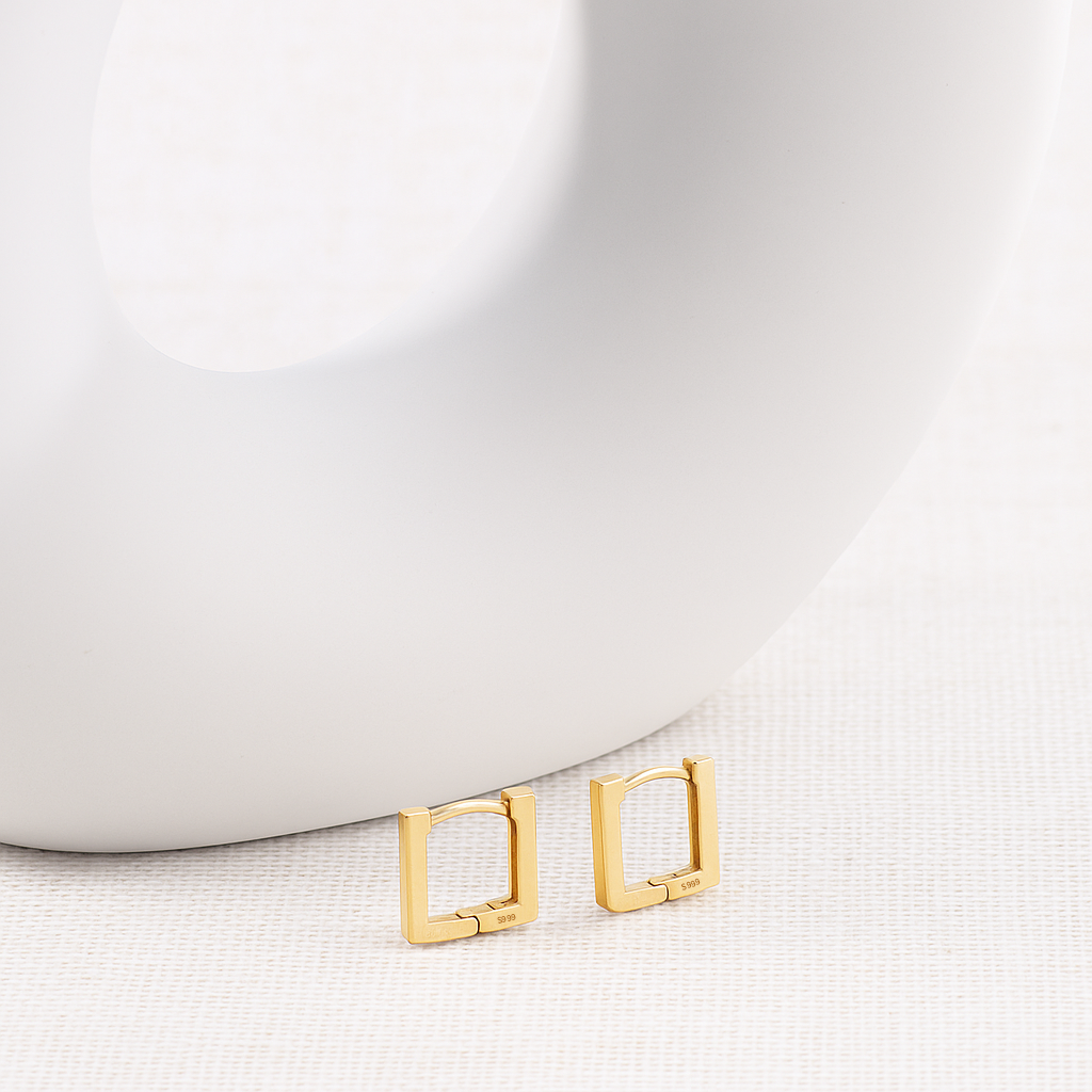 Gold hoop earrings on a white surface