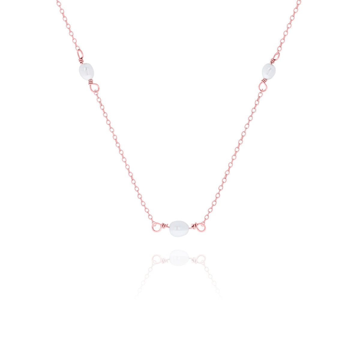 Rose-gold-tone necklace with three white oval beads displayed on a white background