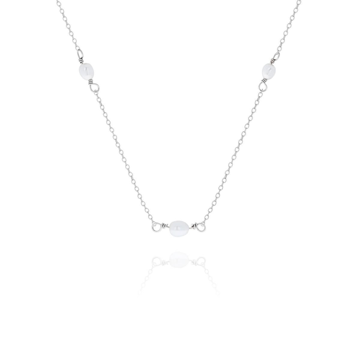 Silver-tone necklace with three white oval beads displayed on a white background